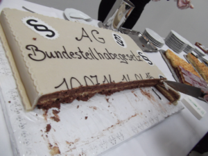 Zu sehen ist ein angeschnittener Schokoladenkuchen mit dem Schriftzug "Bundesteilhabegesetz" und Paragraphenzeichen.